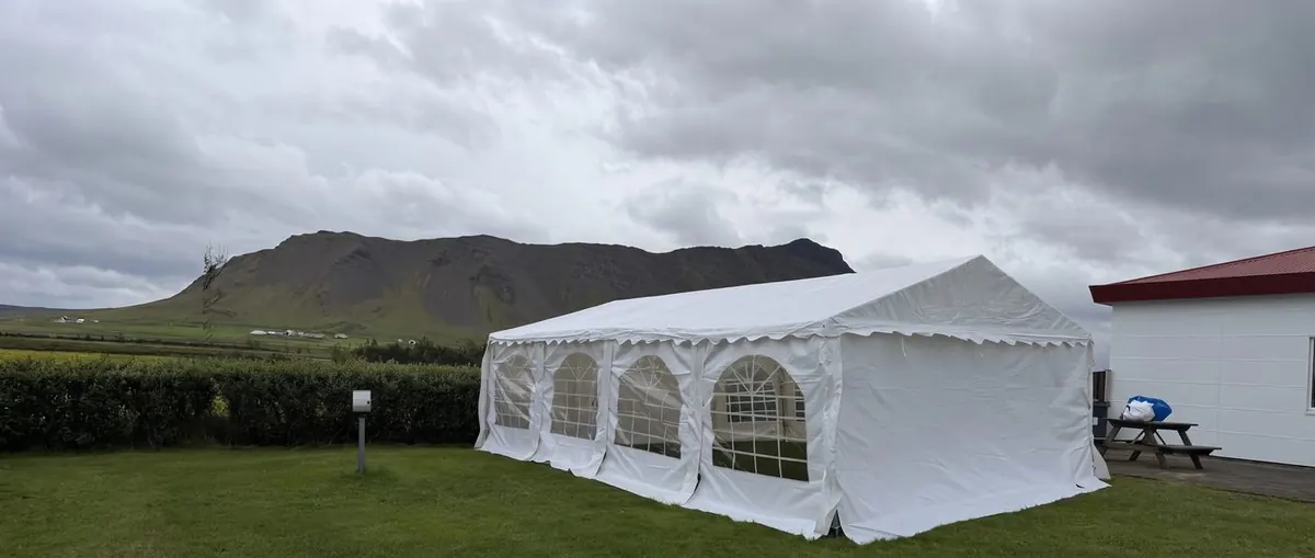Hvítt veislutjald frá RentEvent reist á grasflöt fyrir garðveislu